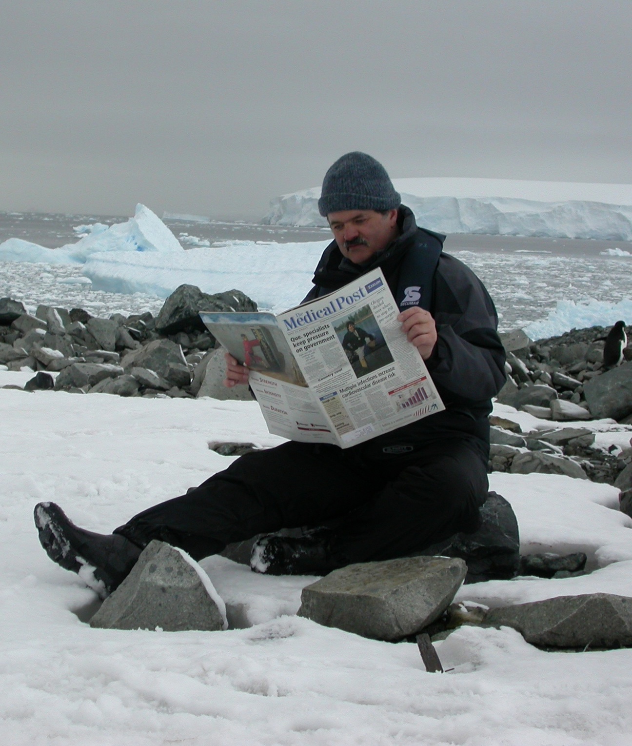 Rand reading the paper by the sea